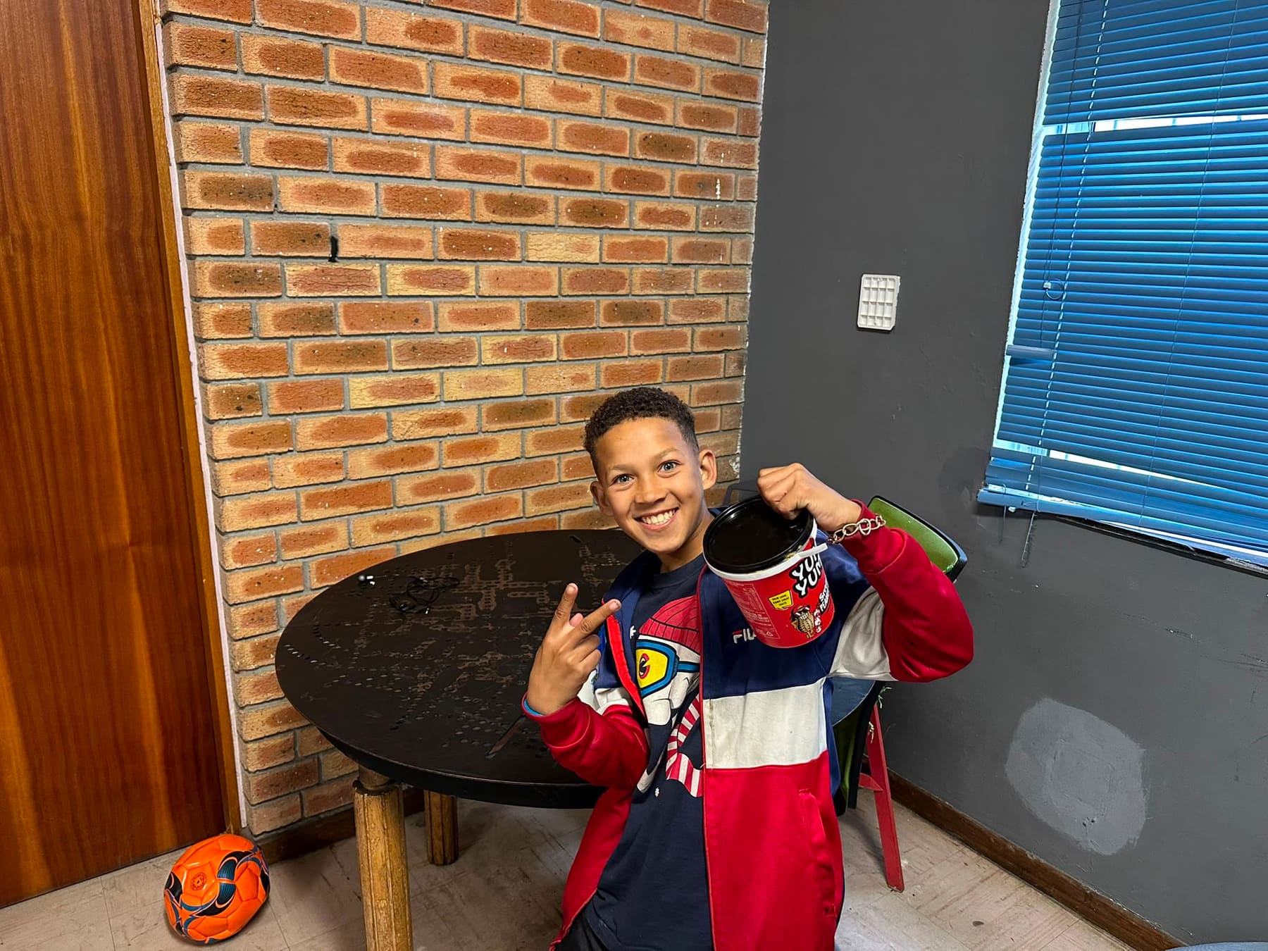 A boy showing his backpack in the community hall