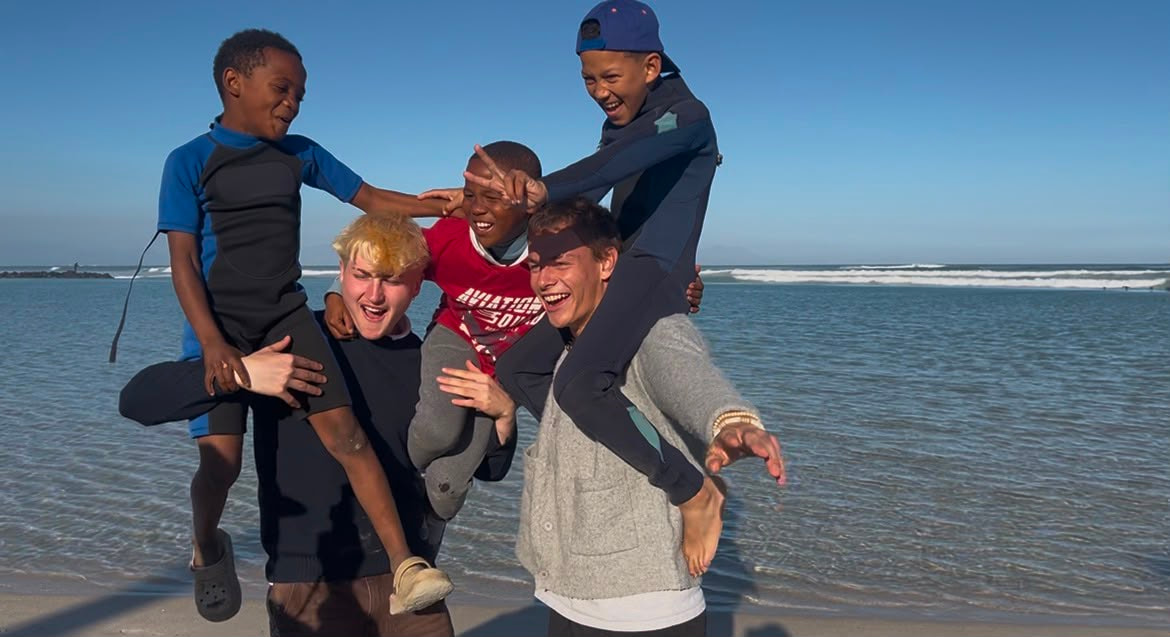 Volunteers lifting children up on the beach
