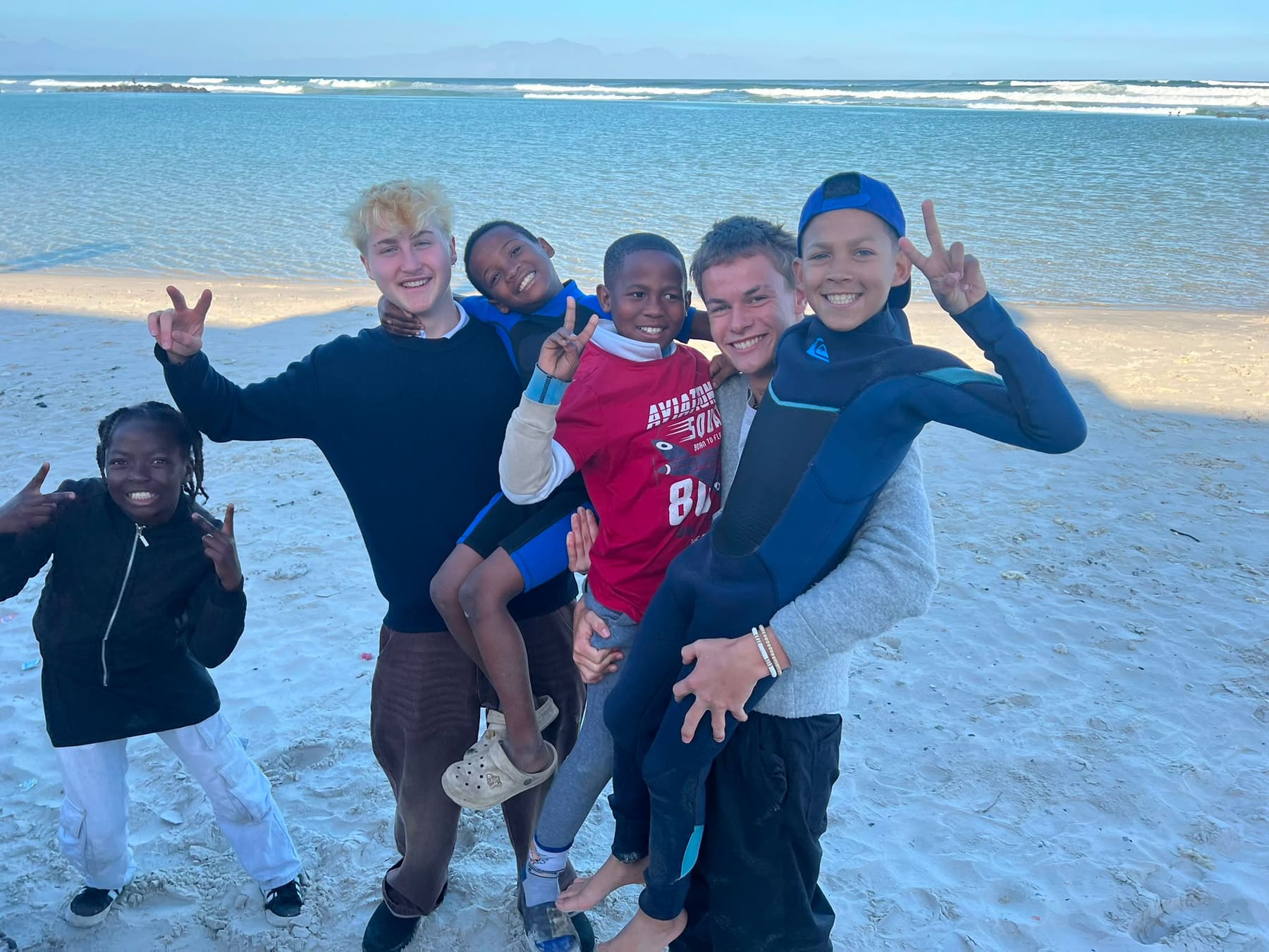 Children and volunteers striking poses on the sand